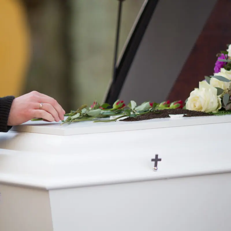 closeup-shot-of-a-person-hand-on-a-casket-with-a-b-2025-02-02-22-37-31-utc